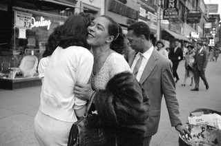 Billie Holiday with Carl Drinkard on Broad Street in New York, receiving a gift from a fan. Jerry Dantzic